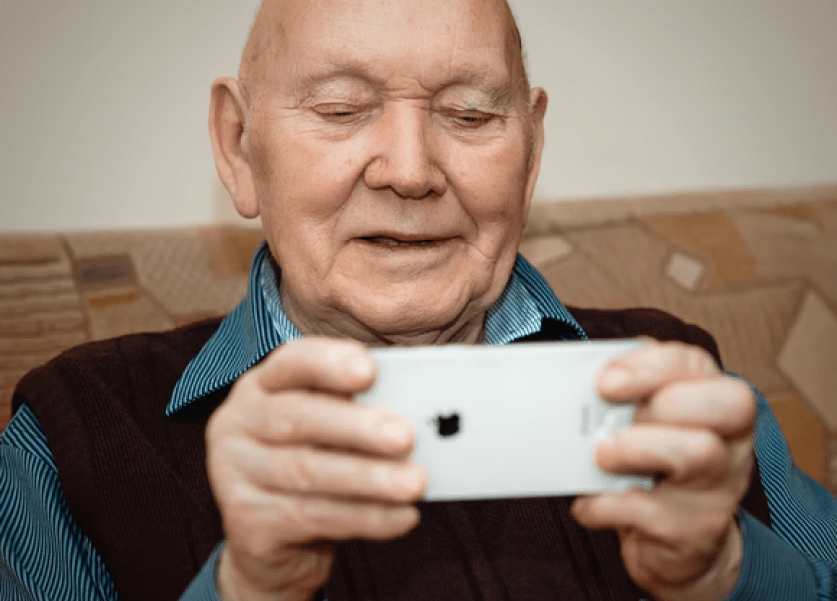anciano mirando la pantalla de un móvil