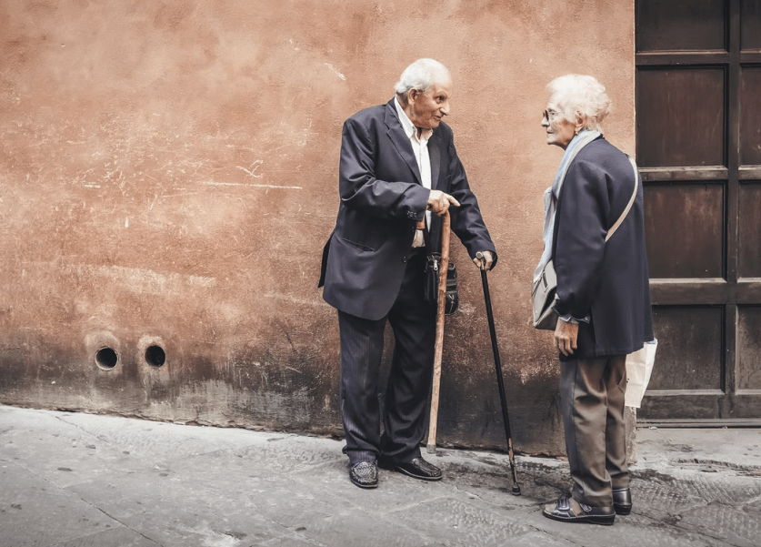 gente mayor hablando en la calle
